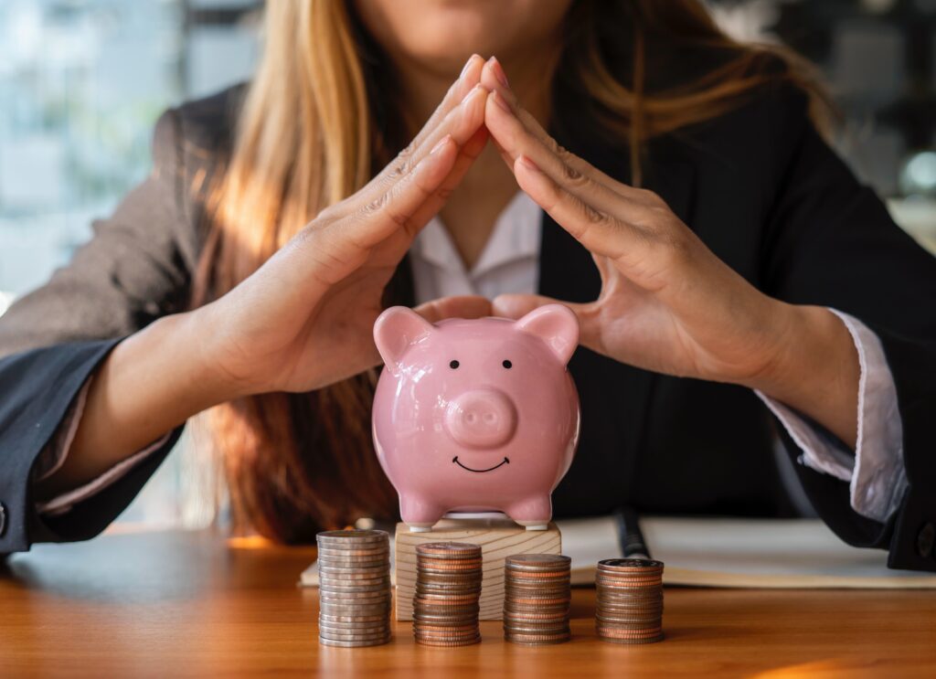 A business woman protecting a piggy bank symbolizing financial safety and savings
