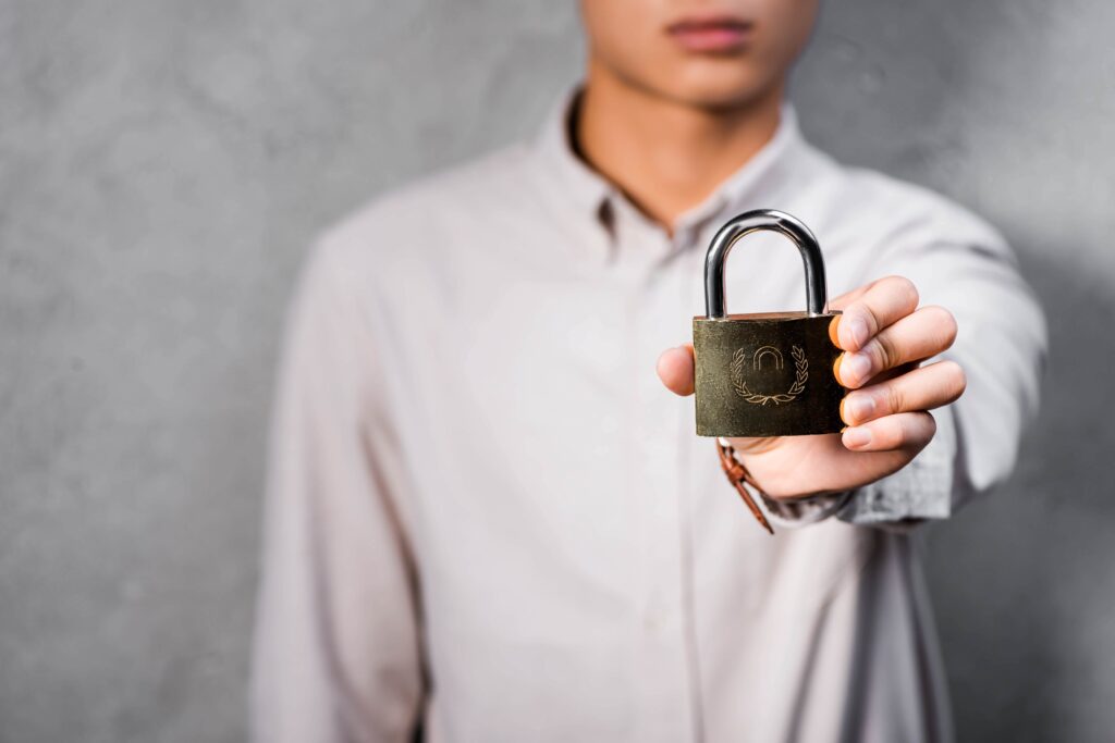 A hand holding a padlock symbolizing security and protection in retirement planning